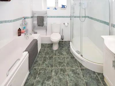 a bathroom with a toilet and a tub and a sink at The Old Farm House in Beetham