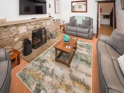 a living room with a couch and a fireplace at The Old Farm House in Beetham