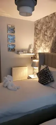 a bedroom with a bed with a white bedspread and pillows at The Dreamcatcher Hotel in Blackpool