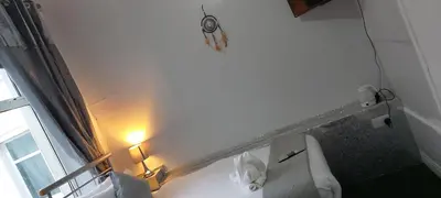 a white bathroom with a toilet and a window at The Dreamcatcher Hotel in Blackpool