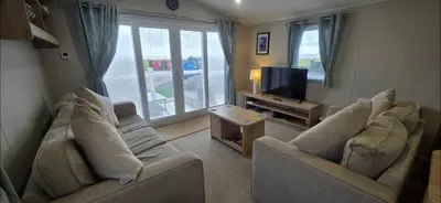 a living room with two couches and a television at Our Sea View - Heysham in Heysham