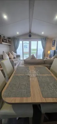 a dining room with a table and a couch at Our Sea View - Heysham in Heysham