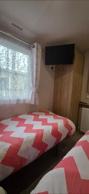 a bedroom with a red and white bed and a television at Our Sea View - Heysham in Heysham