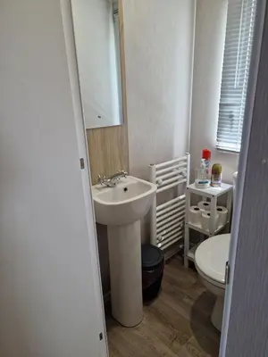 a white bathroom with a sink and a toilet at Our Sea View - Heysham in Heysham