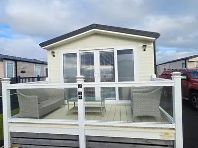 a screened in deck with chairs and a table at Our Sea View - Heysham in Heysham
