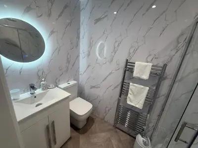 a bathroom with a shower and a toilet and a sink at Rose Cottage by Sasco in Blackpool