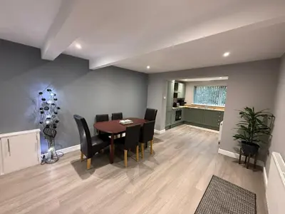 a dining room with a table and black chairs at Rose Cottage by Sasco in Blackpool