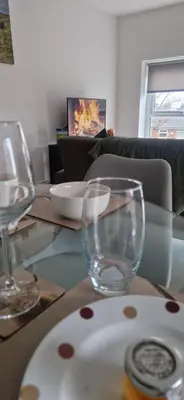 a table with a plate and two glasses on it at Sarah's Woodland Liverpool Stays in Waterloo