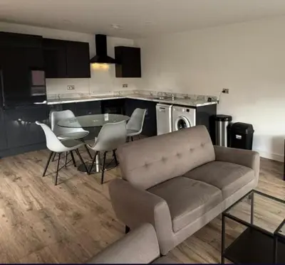 a living room with a couch and a table and chairs at Sarah's Woodland Liverpool Stays in Waterloo