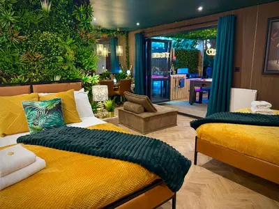 a bedroom with two beds and a living room at The Secret Garden Glamping Lancashire in Skelmersdale
