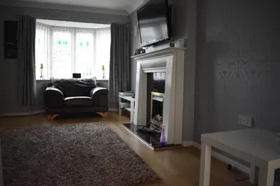 a living room with a couch and a fireplace at Liverpool Redwood house in Liverpool