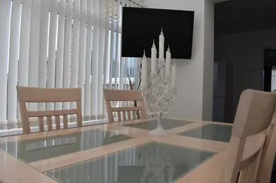 a dining room with a glass table and chairs at Liverpool Redwood house in Liverpool