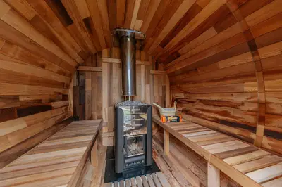 an inside of a log cabin with a stove at Hidden Hills Luxury Glamping in Arkholme