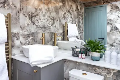 a bathroom with a sink and a mirror at Hidden Hills Luxury Glamping in Arkholme