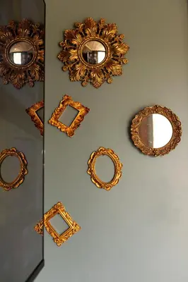 a wall with gold mirrors on a wall at Hidden Hills Luxury Glamping in Arkholme