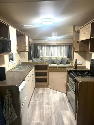 a small kitchen with a couch in the background at Marton Mere 8 Berth Caravan in Blackpool