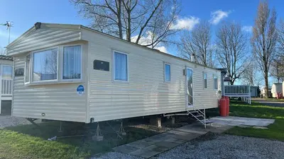 a white tiny house parked in a yard at Marton Mere 8 Berth Caravan in Blackpool