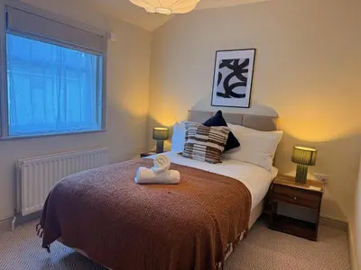 a bedroom with a bed with a teddy bear on it at The Meridian in Southport