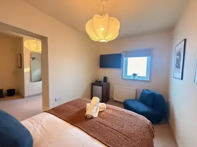 a bedroom with a bed and a blue chair at The Meridian in Southport