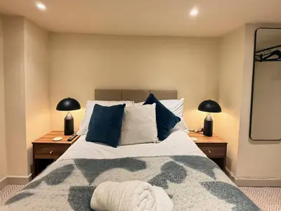 a bedroom with a large bed with blue pillows at The Meridian in Southport