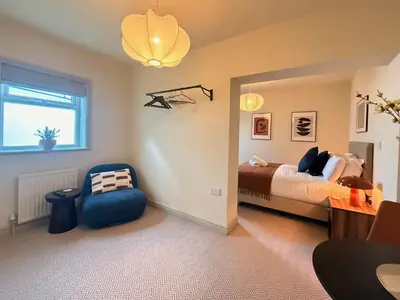 a bedroom with a bed and a chair and a window at The Meridian in Southport