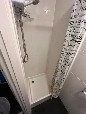a shower in a bathroom with writing on the wall at 1BR Apartment in Blackpool l Sleeps 4, Fully Furnished in Blackpool