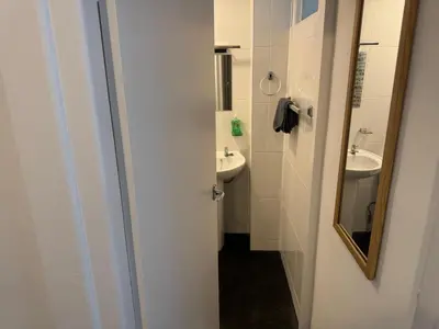 a white bathroom with a sink and a mirror at 1BR Apartment in Blackpool l Sleeps 4, Fully Furnished in Blackpool