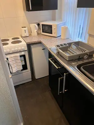 a kitchen with a sink and a stove and a microwave at 1BR Apartment in Blackpool l Sleeps 4, Fully Furnished in Blackpool