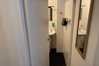 a white bathroom with a sink and a mirror at 1BR in Blackpool l Sleeps 4, Wi-Fi & Full Kitchen in Blackpool