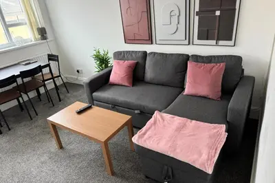a living room with a couch and a table at 1BR in Blackpool l Sleeps 4, Wi-Fi & Full Kitchen in Blackpool