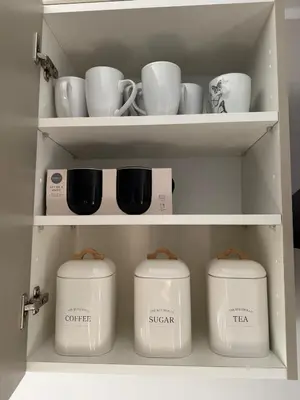 a shelf with cups and tea pots in a kitchen at Livs cozy corner in Crossens