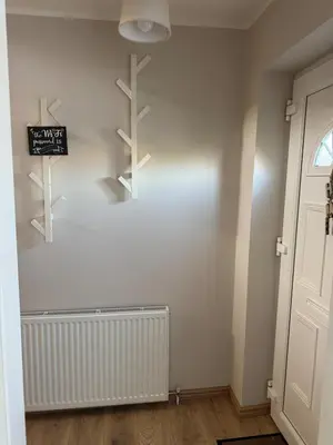 a room with a white wall with shelves and a door at Livs cozy corner in Crossens