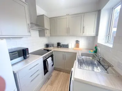 a kitchen with white cabinets and a sink at Three Bedroom House by Brookland Stays Serviced Accommodation & Short Lets in Preston with Free WiFi in Preston