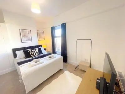 a bedroom with a bed and a desk with a computer at Three Bedroom House by Brookland Stays Serviced Accommodation & Short Lets in Preston with Free WiFi in Preston