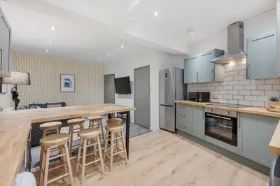 a kitchen with wooden counter tops and bar stools at Earle House - Air Host & Stay - 5 BR - Sleeps 13 in Liverpool