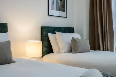 a hotel room with two beds and a lamp at Earle House - Air Host & Stay - 5 BR - Sleeps 13 in Liverpool