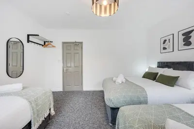a bedroom with two beds and a mirror at Earle House - Air Host & Stay - 5 BR - Sleeps 13 in Liverpool