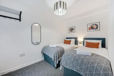 a bedroom with two beds and a mirror at Earle House - Air Host & Stay - 5 BR - Sleeps 13 in Liverpool