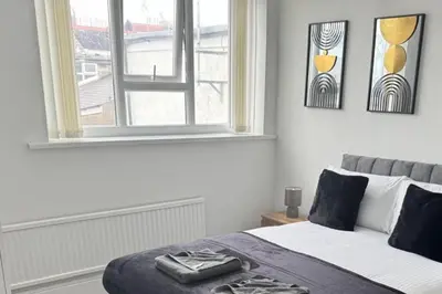 a bedroom with a bed with a window and a suitcase on it at 1BR in Blackpool l Sleeps 4 l Contractors in Blackpool