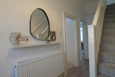 a mirror on a wall next to a staircase at 7-Bed Contractor House in Wallasey- free parking in Wallasey