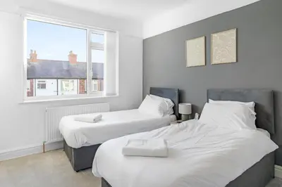 two beds in a room with a window at 7-Bed Contractor House in Wallasey- free parking in Wallasey