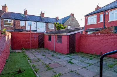 a red brick house with a red fence at 7-Bed Contractor House in Wallasey- free parking in Wallasey