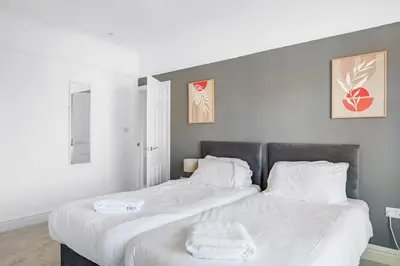 a bedroom with a large bed with white sheets at 7-Bed Contractor House in Wallasey- free parking in Wallasey