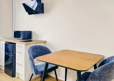 a table with blue chairs and a microwave and a table with a microwave at Park Hall Resort And Spa in Chorley