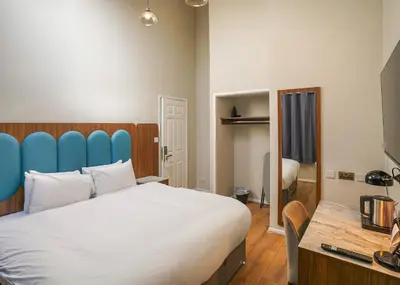 a bedroom with a large bed with a blue headboard at Park Hall Resort And Spa in Chorley