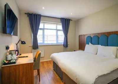 a bedroom with a bed and a desk and a window at Park Hall Resort And Spa in Chorley