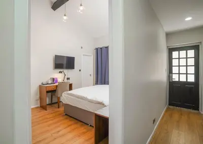 a bedroom with a bed and a desk with a television at Park Hall Resort And Spa in Chorley