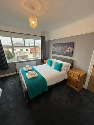 a bedroom with a bed and a large window at Stanley Suite in Liverpool