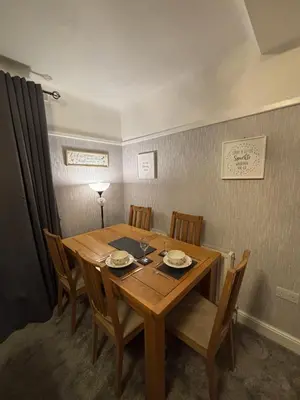 a wooden dining room table with chairs and a lamp at Stanley Suite in Liverpool