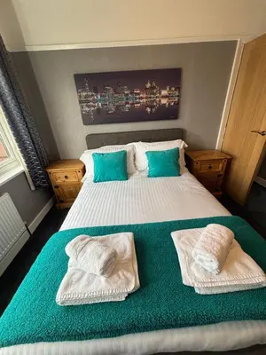 a bedroom with a large bed with towels on it at Stanley Suite in Liverpool